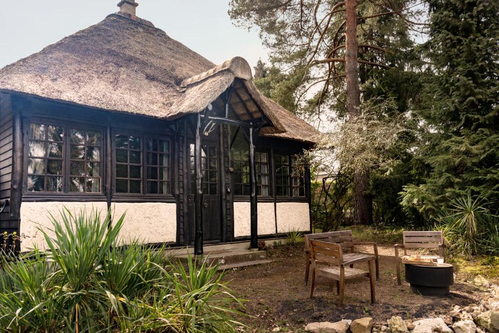 a blue and white building with a thatched roof at Neska Lodge in Saint-Rémy-lʼHonoré