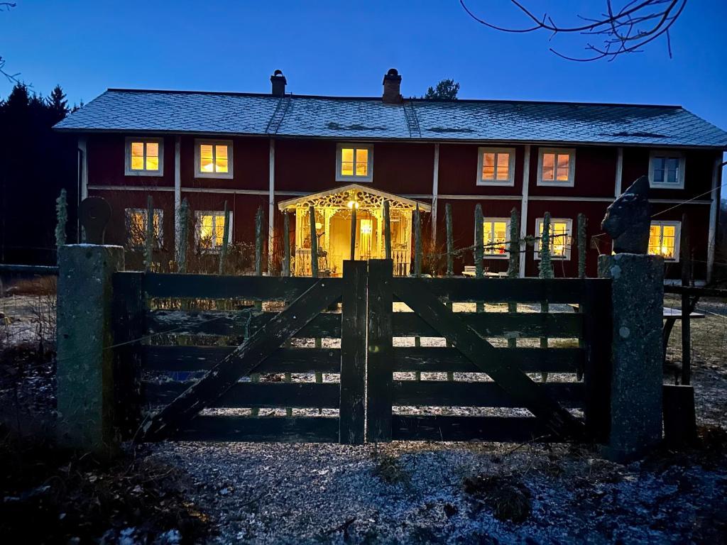 een rood huis met een hek ervoor bij Villa Rönhult in Vilshult
