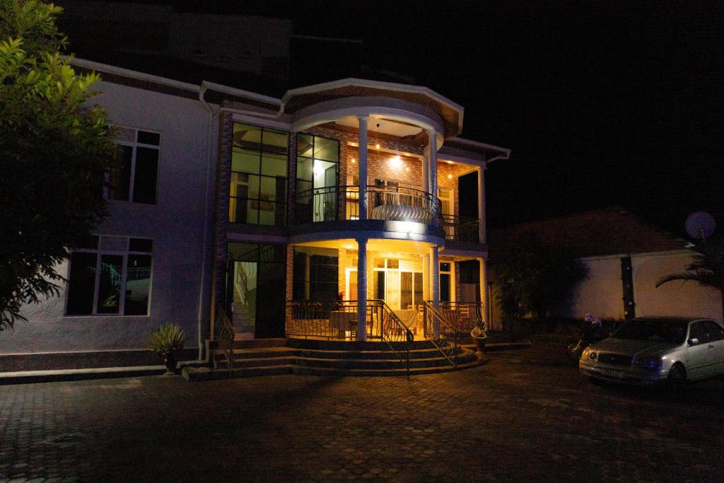 ein großes Haus in der Nacht mit einem Auto vor dem Haus in der Unterkunft COMFORT HOTEL Ltd in Gasanze