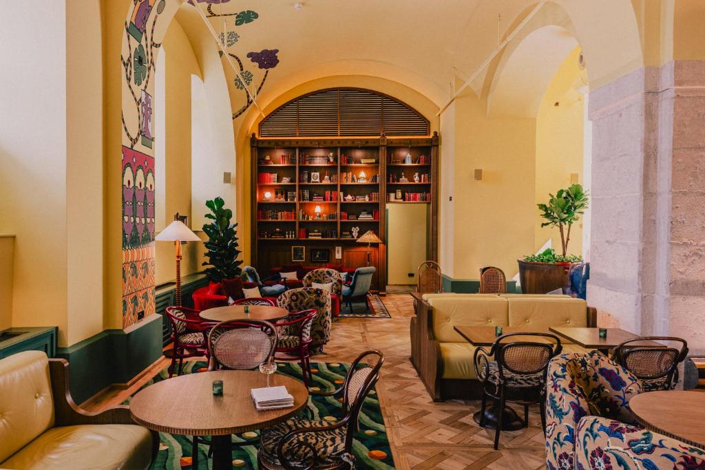 a restaurant with tables and chairs and a library at Wilde Vienna Fleischmarkt in Vienna