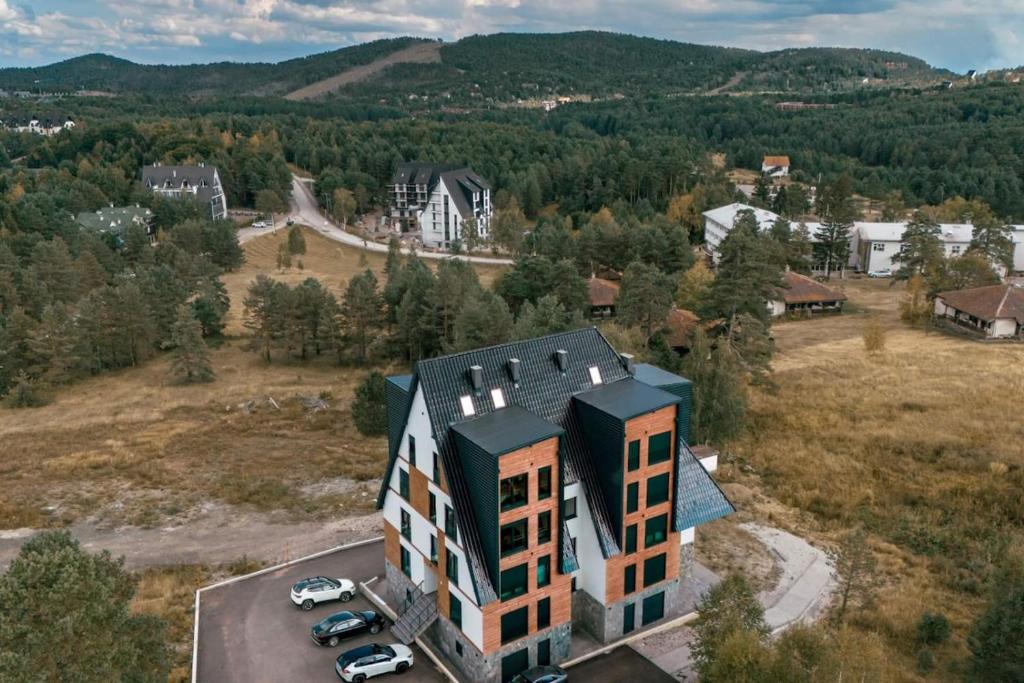 an aerial view of a building with cars parked in a field at Green Peak in Divčibare