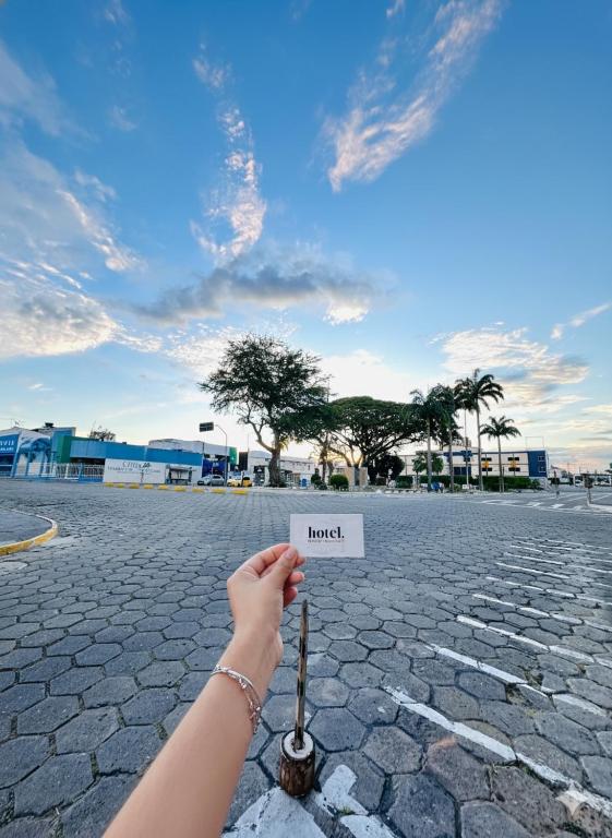a hand holding a stick with a sign that reads fraud at Hotel Dairy Walley in Itapetinga