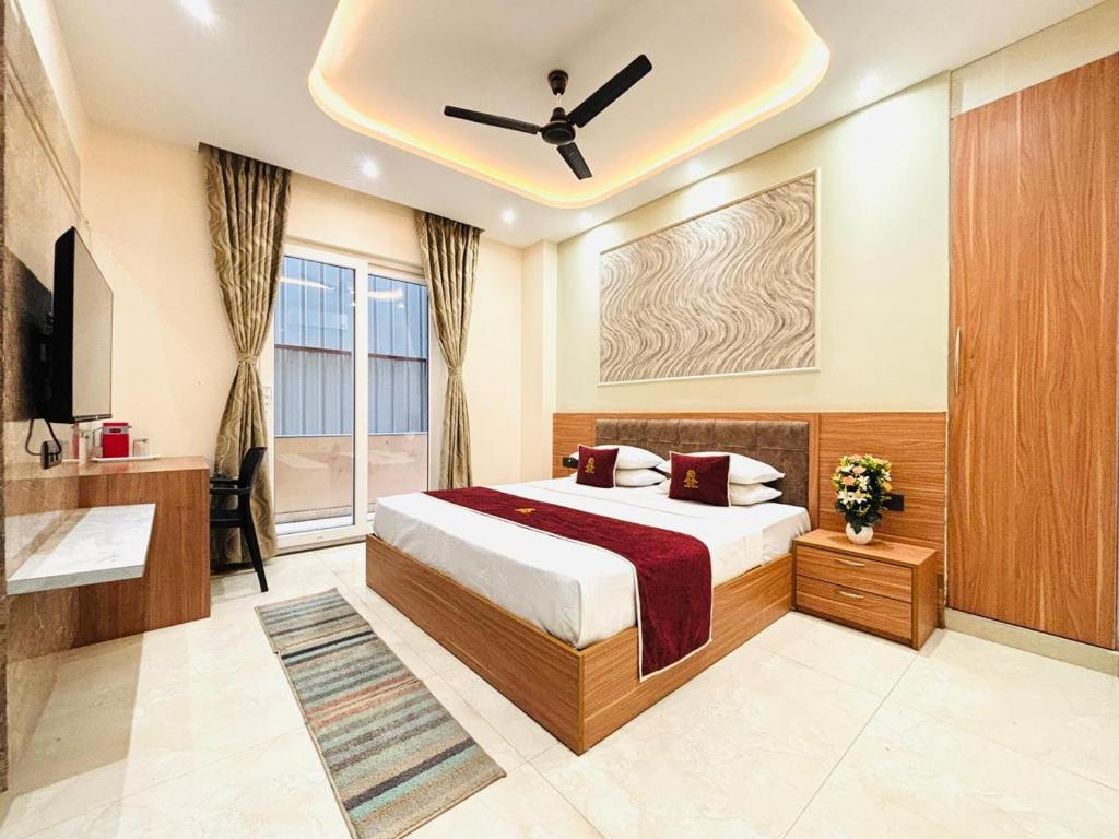 a bedroom with a bed and a ceiling fan at Goel Villa and Hotel in Allāhābād Junction