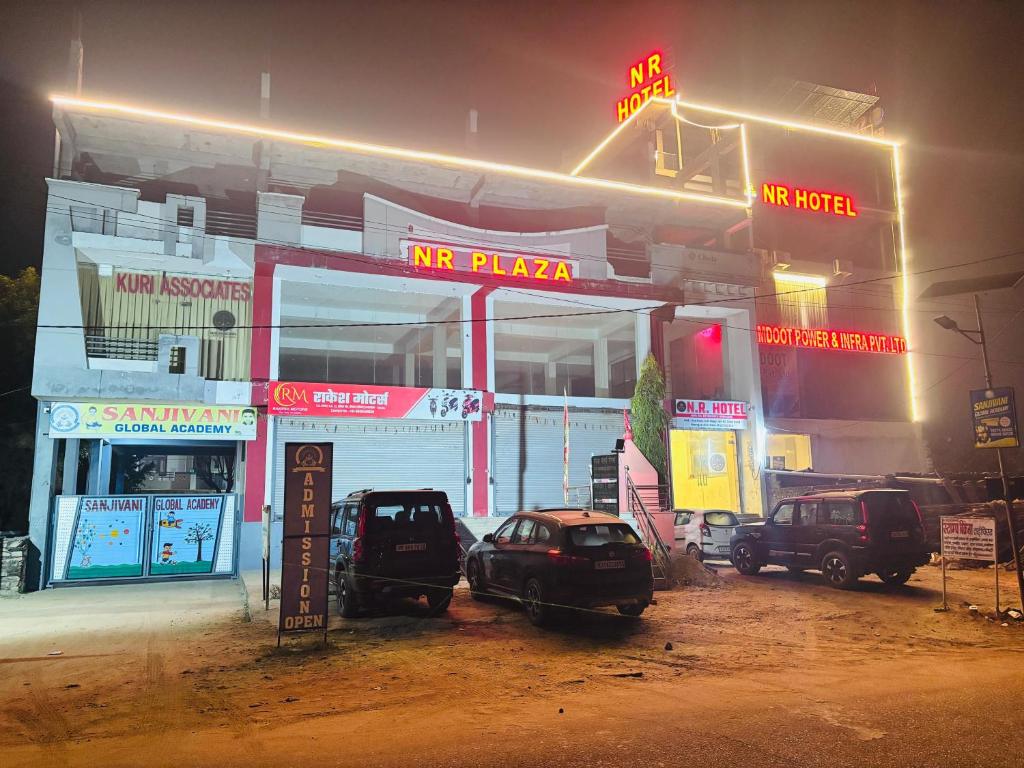 a gas station at night with cars parked in front at NR Hotel in Rīngas