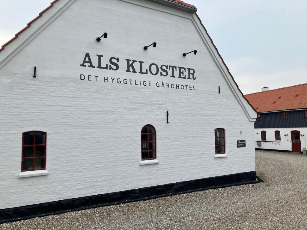 a white building with a sign on the side of it at Als Kloster in Sønderborg