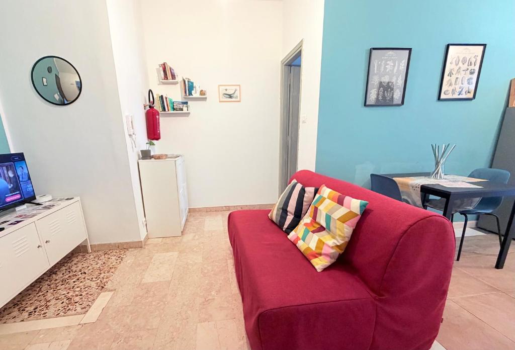 een woonkamer met een rode bank en een tafel bij Jaky Maison Torino, Cozy & Modern Stay in Turijn