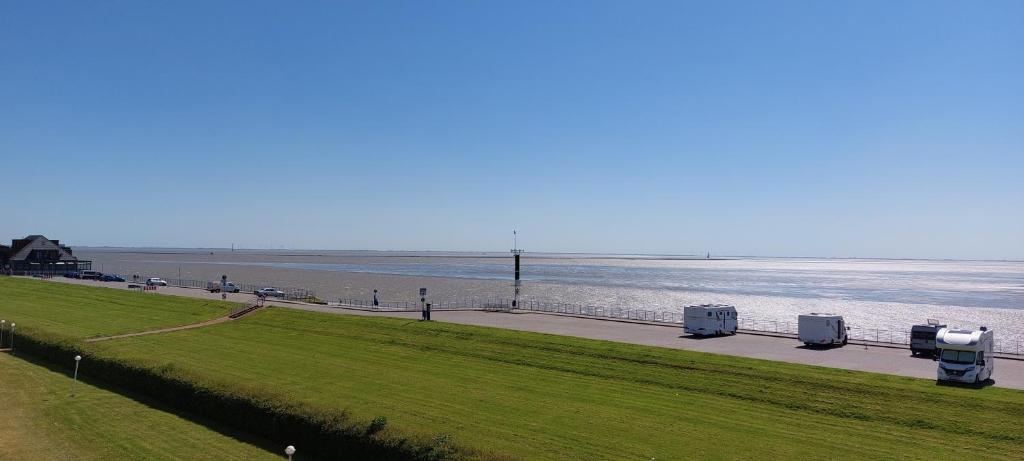 a road next to a body of water at Exklusive Ferienwohnung am Südstrand mit Wintergarten, Balkon & Meerblick Wohnung 22 in Wilhelmshaven