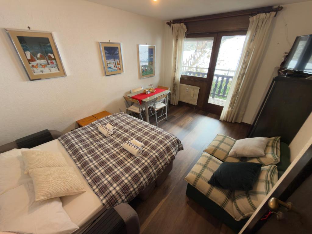 a small bedroom with a bed and a chair at Neve 5 Apartment - Clotes Slope Access in Sauze d'Oulx