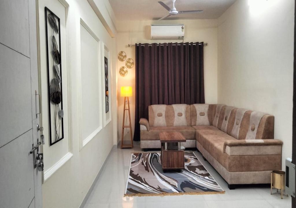 a living room with a couch and a table at Sunset stay in Daman
