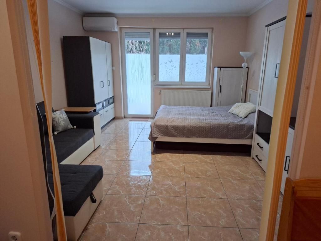 a bedroom with a bed and a tv and a couch at Benett Apartman in Győr