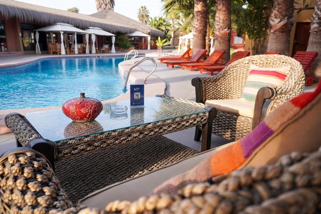 a table and chairs next to a swimming pool at Hotel Serena Suite in La Serena