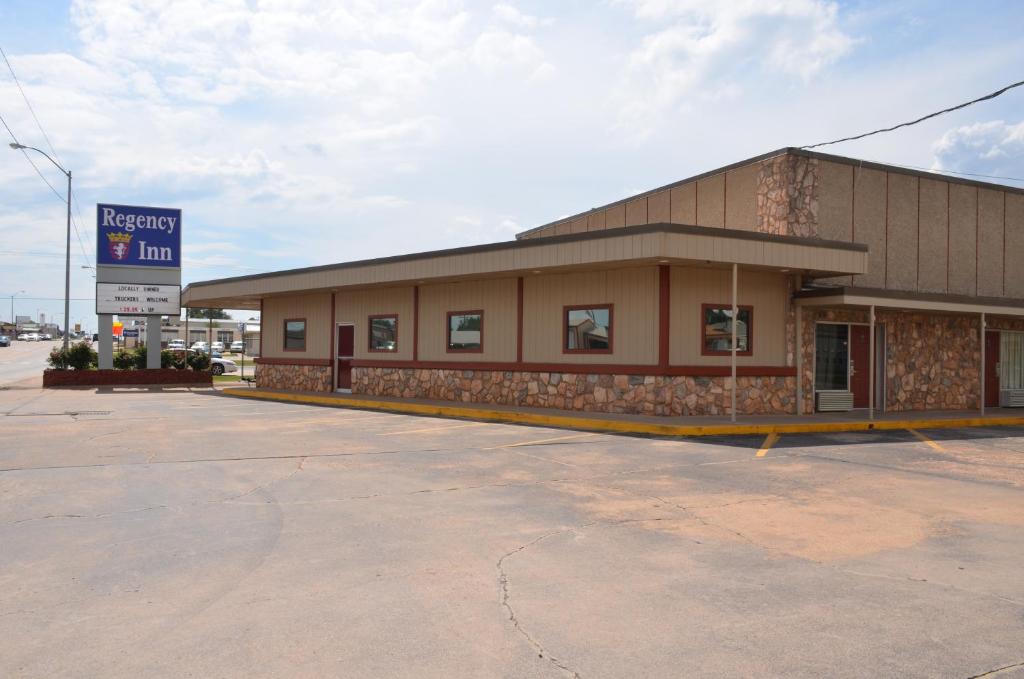 a large building with a sign in front of it at Regency Inn in Chickasha