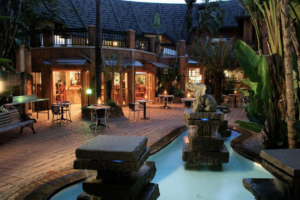 a patio with a water fountain in front of a building at Green Haven Guest Lodge in Pretoria