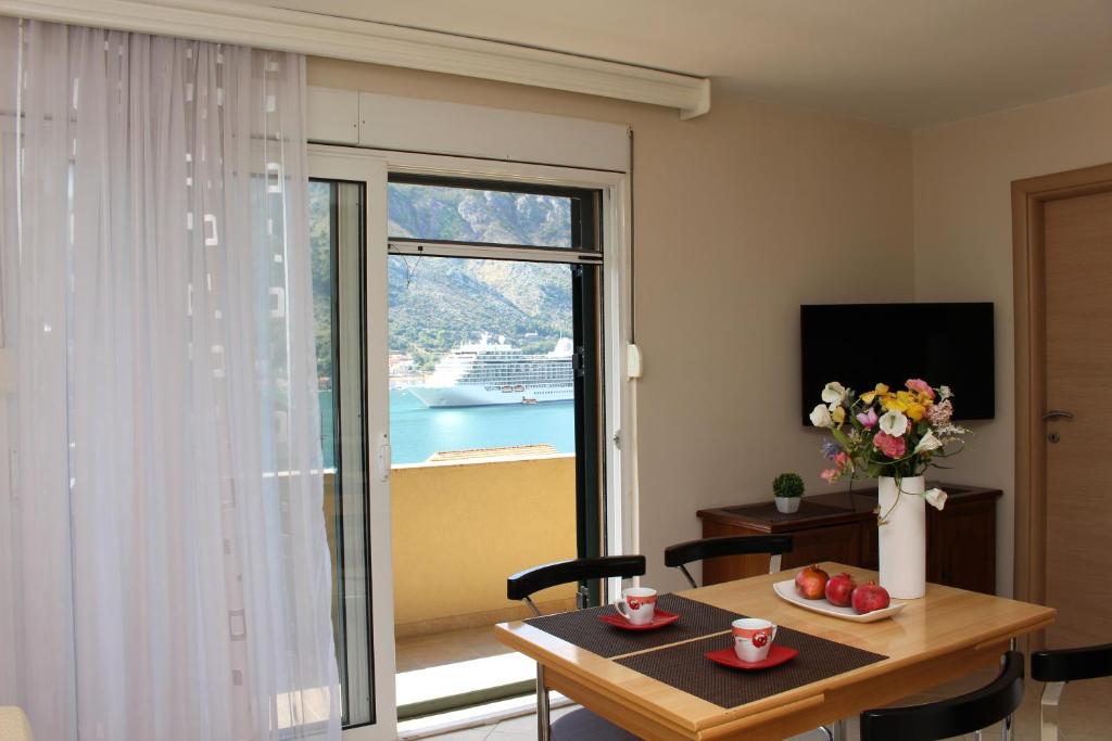 uma sala de estar com uma mesa e uma grande janela em Apartments Kordić em Kotor