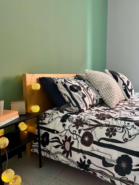 a bed with black and white sheets and pillows at Fuori Arena in Casalecchio di Reno
