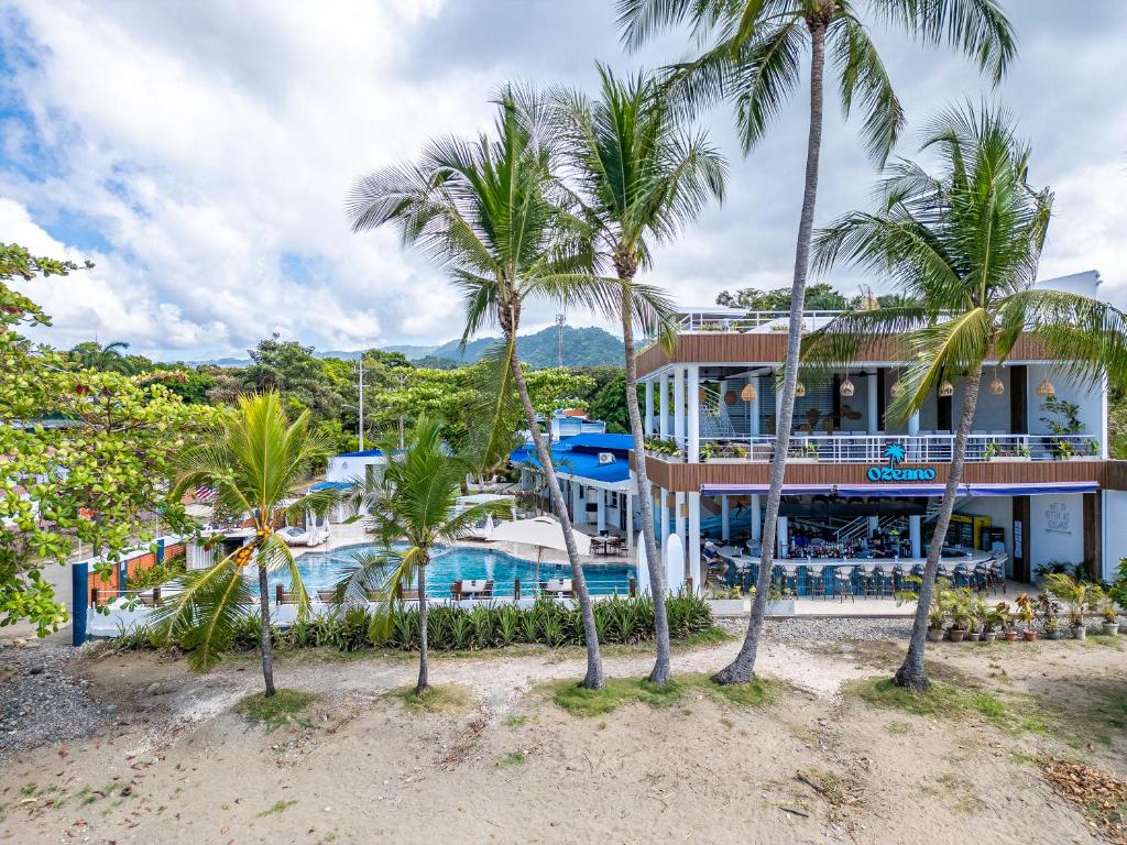 a resort with a pool and palm trees at Ozeano Hotel & Surf Bar in Jacó
