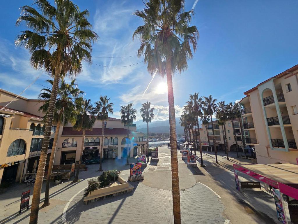 a street with palm trees and benches in a city at T2 cosy et rénové avec vue sur le port d'Argelès pour 4 personnes in Argelès-sur-Mer