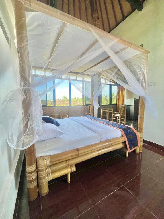 a bed with a canopy in a room at Tutwin Guesthouse in Krambitan