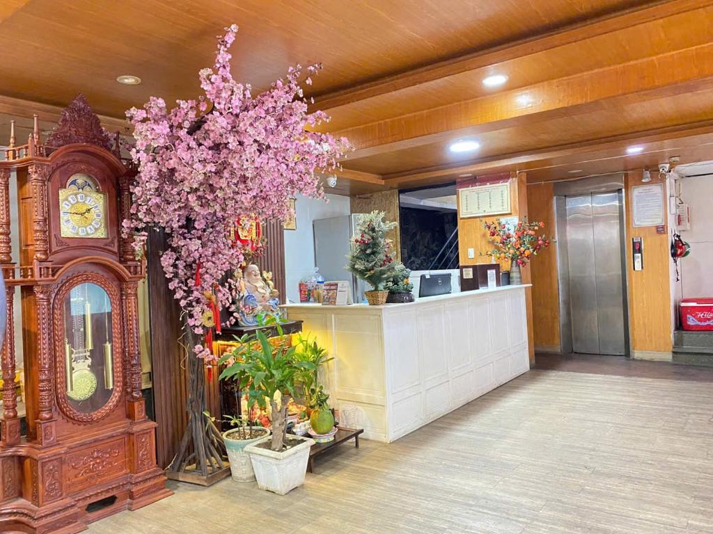 a store with a clock and a tree with pink flowers at Văn An Hotel in Ho Chi Minh City