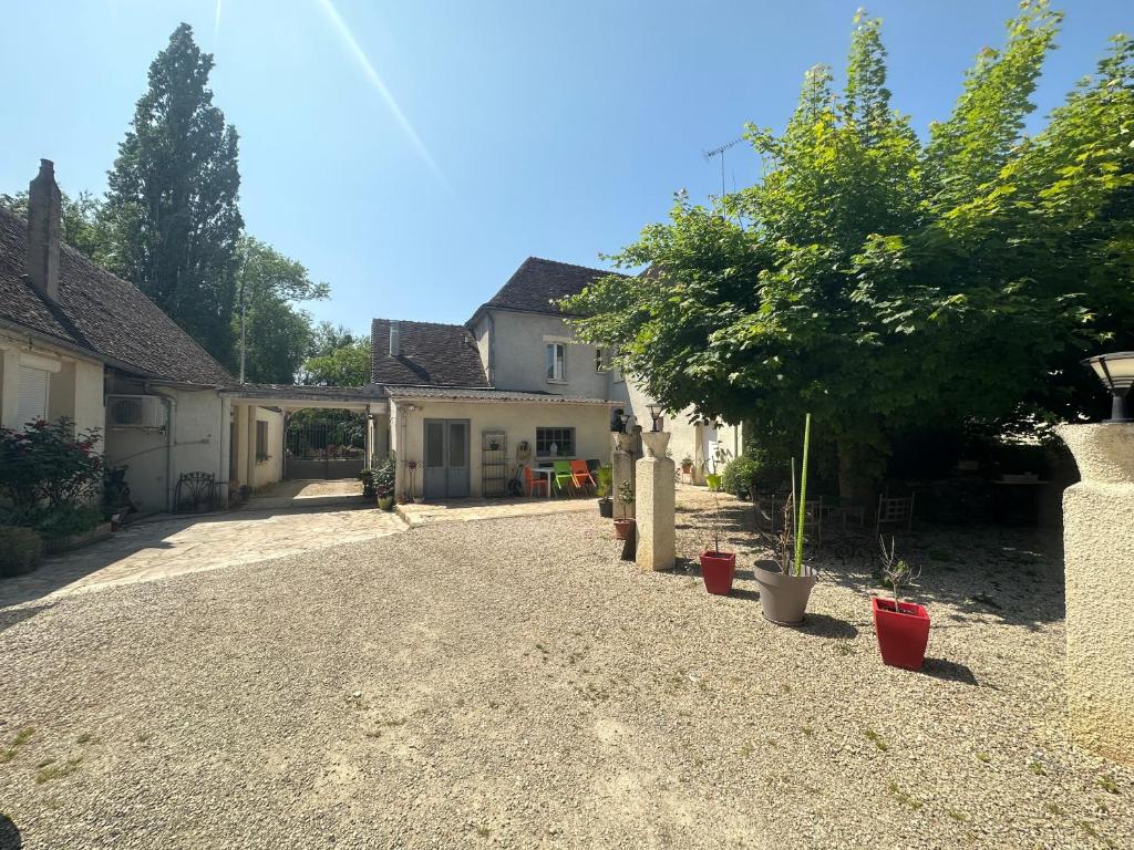 a driveway of a house with a tree and plants at Auberge aux 1000 saveurs in Malay-le-Petit