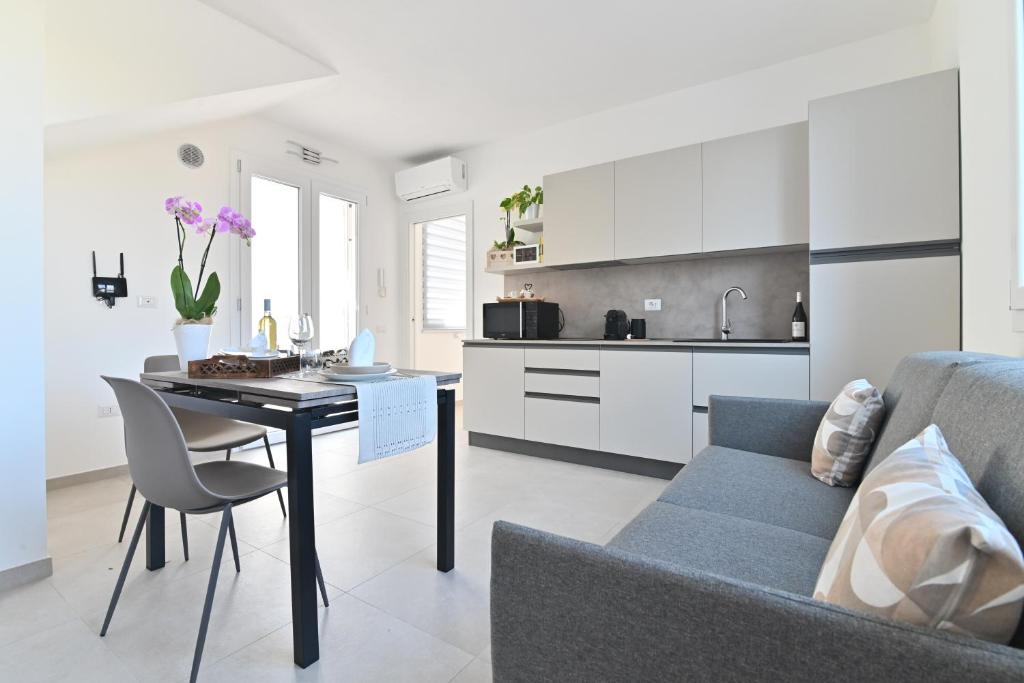 a kitchen and living room with a table and a couch at Congiu's Apartments in Pula