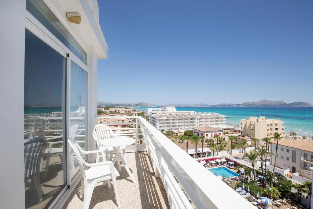ein Balkon mit Stühlen und Meerblick in der Unterkunft Hotel Sultán in Can Picafort