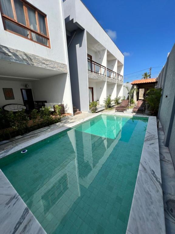 a swimming pool in front of a house at Toca do Lobo in Pipa