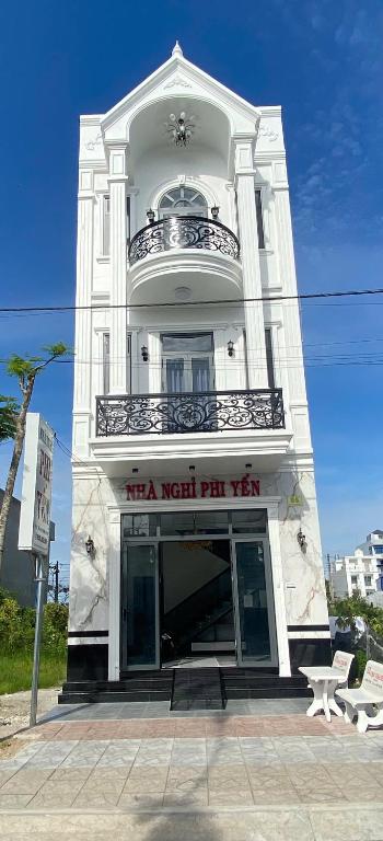 a large white building with a balcony on top at Nhà Nghỉ Phi Yến in Phụng Hiệp