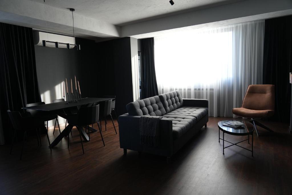a living room with a couch and a table at Flat 6 - Luxury Designer Apartment in Odăile