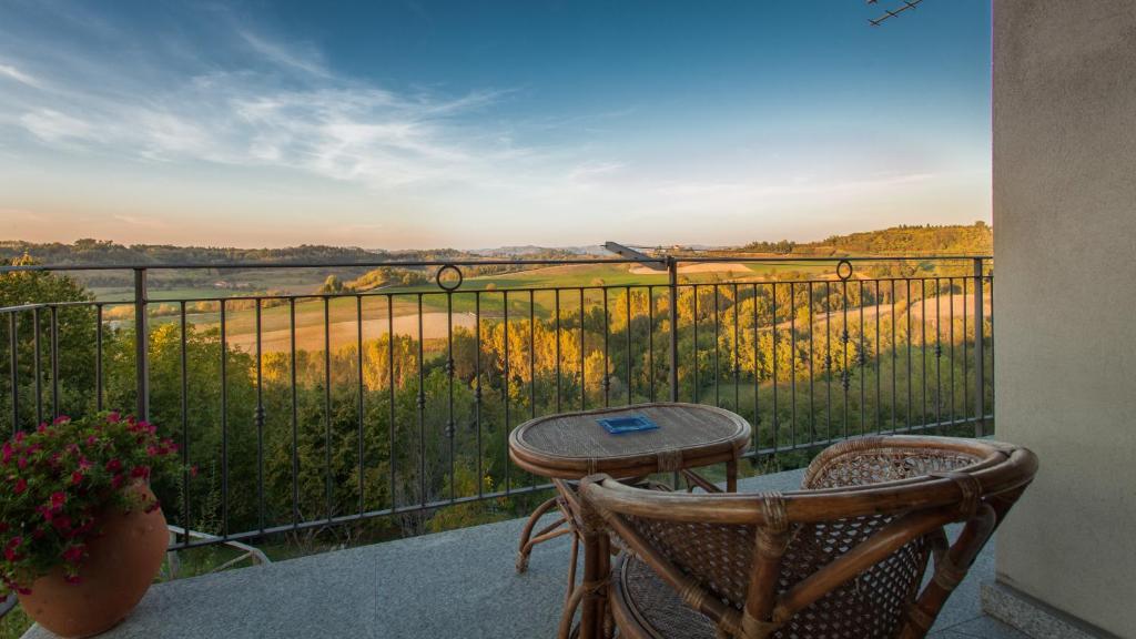 a balcony with a table and chairs and a view at Il Gelso 'd la Costa in Lesegno
