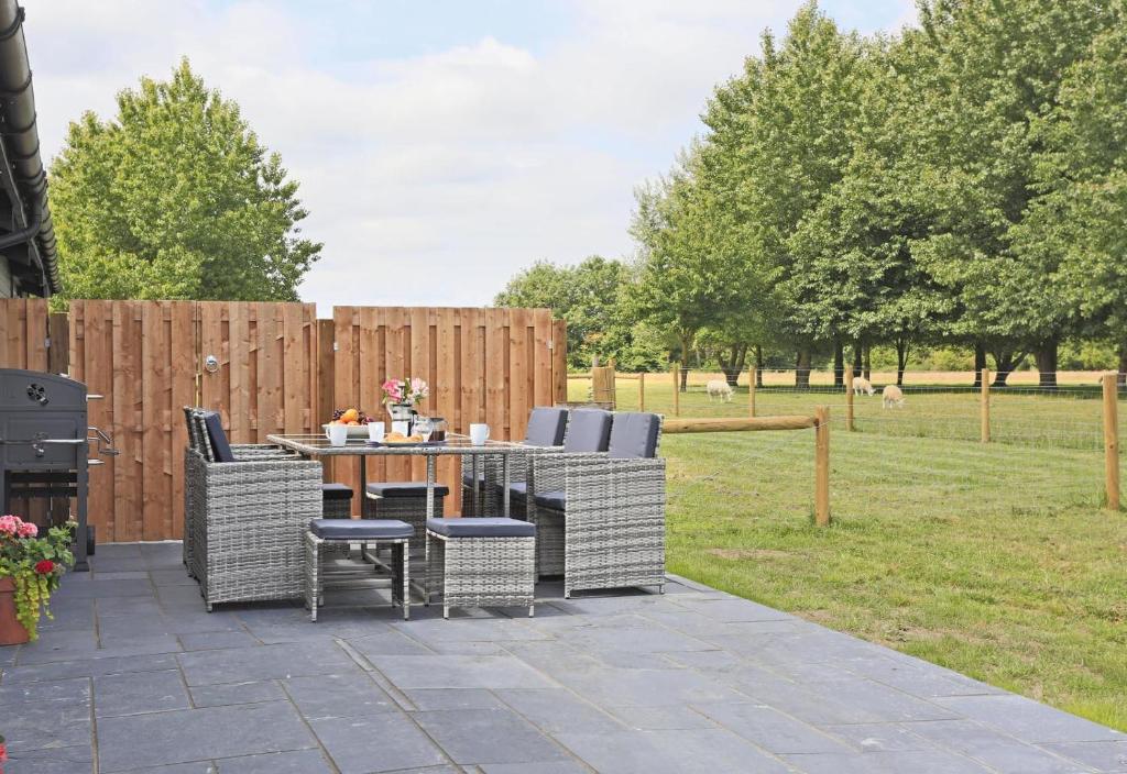 a patio with a table and chairs and a fence at 3 Bed in Barsham oc-bbarn in Beccles