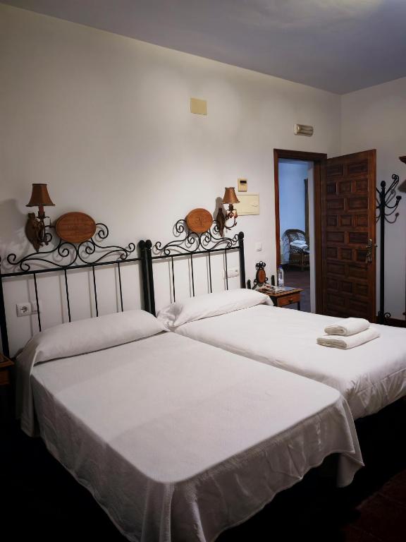 two beds sitting next to each other in a bedroom at Hostal Casa Inés La Valerosa in Las Navas de la Concepción