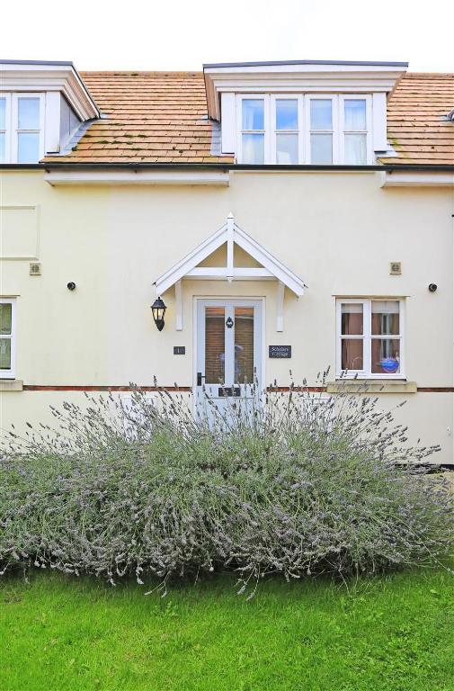 a white house with a large bush in front of it at 2 Bed in Southwold oc-scl in Reydon