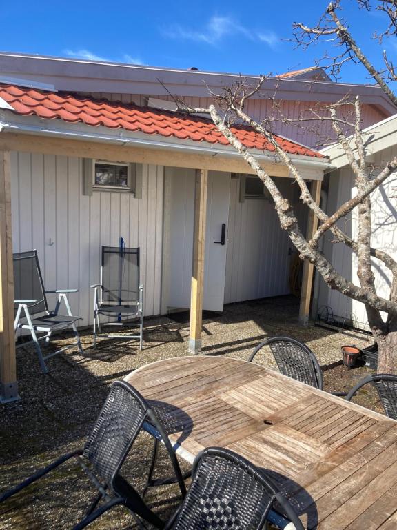een patio met een houten tafel en stoelen bij Lugnt och centralt in Strömstad