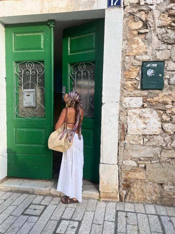 a woman standing in front of a green door at Nesa Beach Front Apartment in Poreč