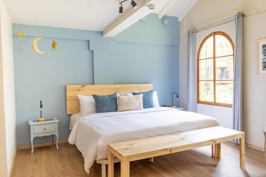 a bedroom with a bed and a wooden bench at Tariq Sacred Valley in Urubamba