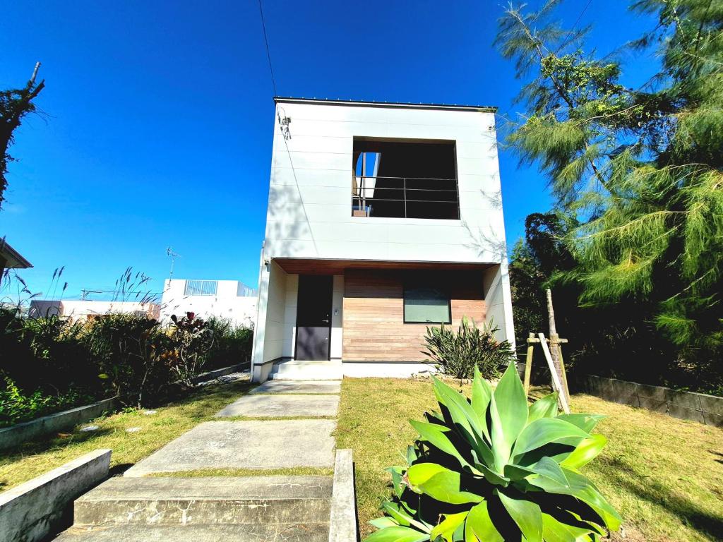 a white house with a window on the side of it at Villa YUKUI in Onna