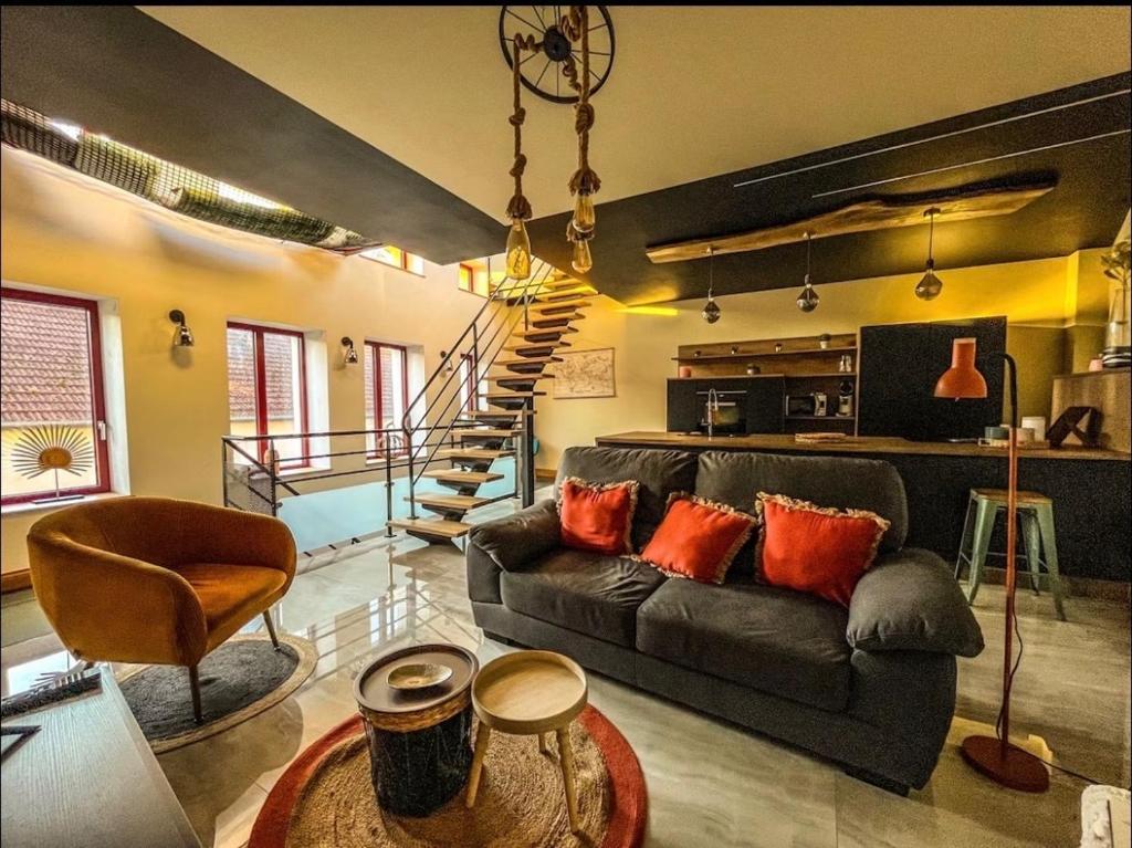 a living room with a black couch and a staircase at Loft Moderne Avec Jacuzzi Roft top Le B in Baccarat