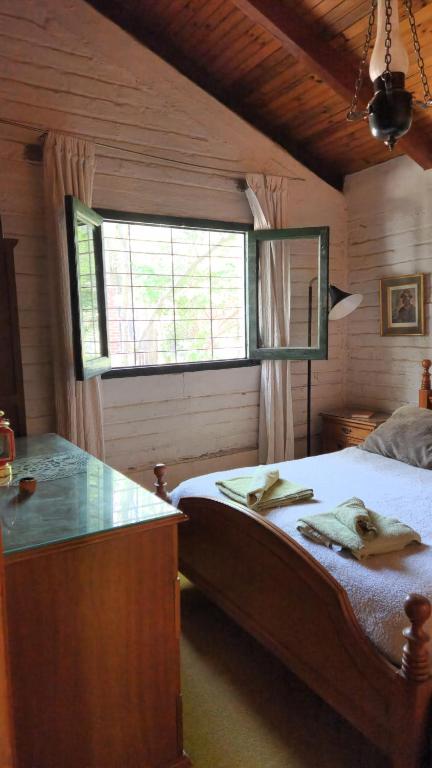 ein Schlafzimmer mit einem großen Bett und einem Fenster in der Unterkunft Cálida casa de montaña in Potrerillos