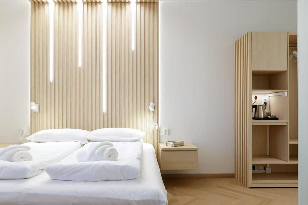 a bedroom with a bed with white sheets and pillows at Polar Nook Hotel in Rovaniemi