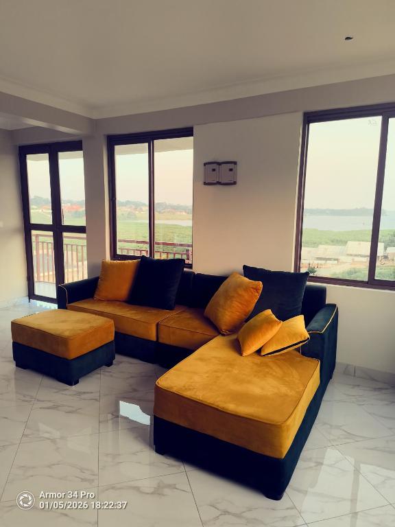 a living room with two couches and large windows at Nordik Hotel in Nkumba