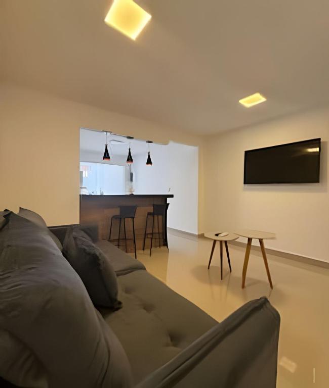 een woonkamer met een bank en een tafel bij RM hospedagem unidade Amapá 2 in Cabo Frio