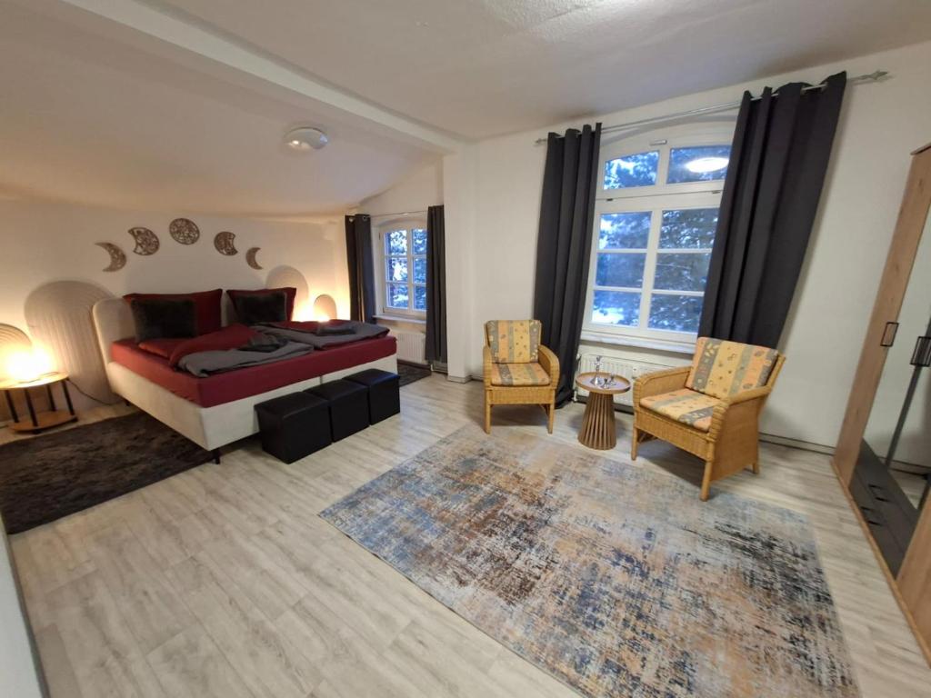 a bedroom with a bed and two chairs and a rug at FeWo im Herzen Tarnows in Tarnow