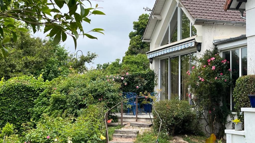 a house with flowers and plants in front of it at Le chant des roses in Giverny