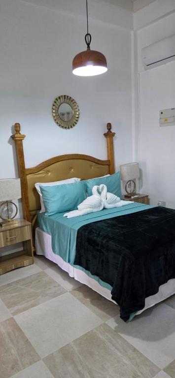 a bedroom with a large bed with a black blanket at Martha's House Lexus in Soufrière