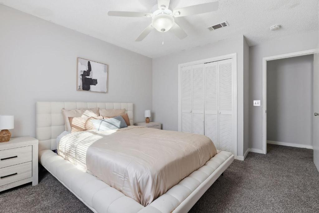 a white bedroom with a bed and a ceiling fan at Comfortable 2BR2BA with Modern Touches in Jackson