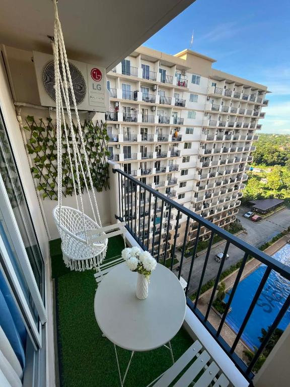 a balcony with a swing and a table with flowers at seakyung village in Suba