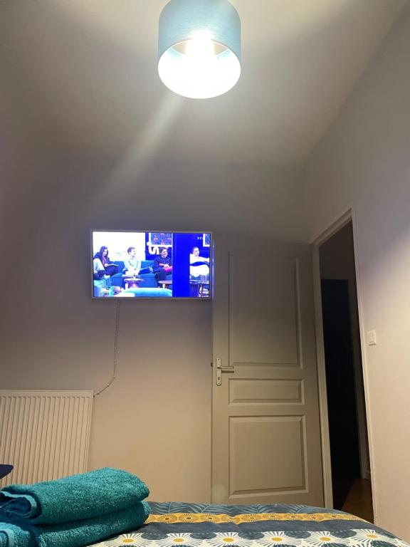 una TV a schermo piatto sulla parete di una camera da letto di le ROYAT a Royat