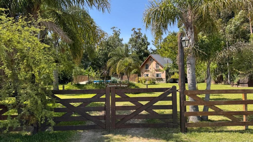 a wooden fence in front of a house at Encantos del Bosque in Colón