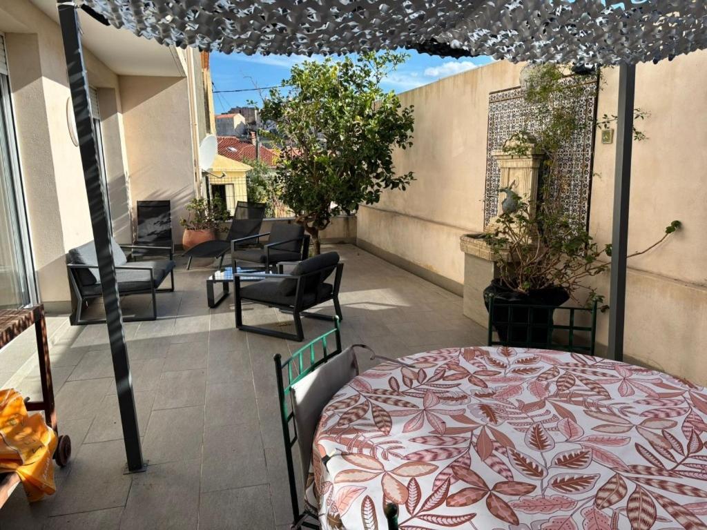 a balcony with a bed and an umbrella at Casa di a Murza vue citadelle Rdc in Calvi